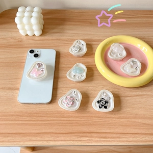 Sparkling rhinestone flower and butterfly cell phone pop-sockets on a light wood desk