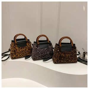 Close-up of three leopard print handbags with wooden handles and gold stud details