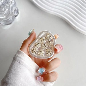 Detail of heart-shaped phone grip with 3D silver-white roses and pearlescent finish