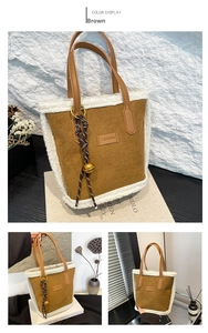 Close-up of brown suede tote bag featuring plush fleece trim and fashion logo detail