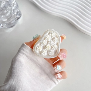 Detail of a white 3D floral resin phone socket held by hand with aesthetic manicure