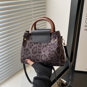 Fashionable leopard print handbag with round wooden handles and adjustable shoulder strap