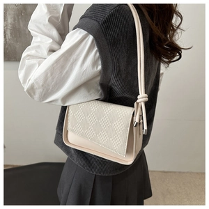 Detail of off-white crossbody bag with woven texture lid and smooth leather finish