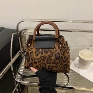 Chic leopard print handbag with gold rivets on silver metal rack display