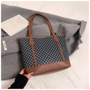 Detail of vintage tote bag featuring geometric print with brown leather trim and handles