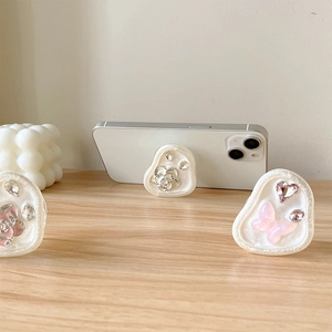 Sparkly floral and butterfly rhinestone pop sockets on a white marble phone grip base