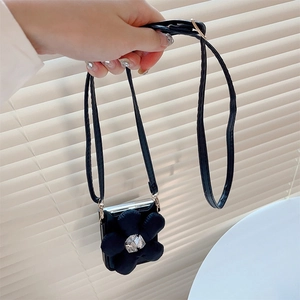Detail view of the black crossbody phone case featuring a large 3D flower with crystal center