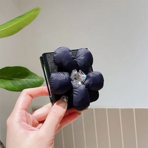 Detail view of foldable phone case with a large 3D fabric flower and crystal accents