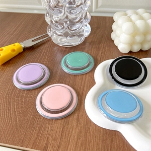 Close-up of five colorful pastel magnetic phone socket stands on a dark wooden table