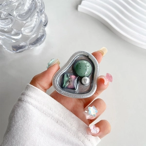 Artistic collage phone grip featuring purple resin, green dots, and pearl in silver frame