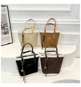 Detail of four suede tote bags with faux shearling trim and decorative gold bell charms