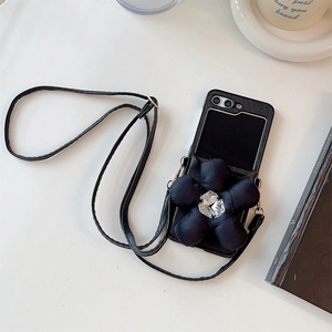Close-up of black leather phone case with large 3D flower and adjustable crossbody strap