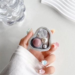 Detail showing a heart-shaped phone grip with pink beads and white pearls on silver frame