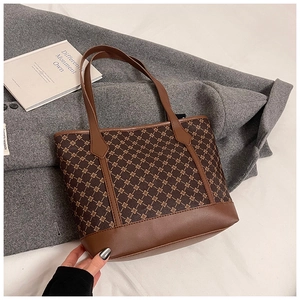 Macro detail of retro tote bag with brown geometric print and leather handle stitching