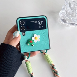 Detail der minzgrünen Falthülle mit 3D-Frosch und gewebtem Trageband für Handy