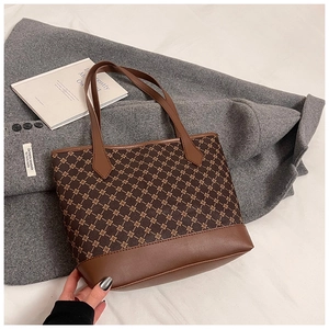 Detail of vintage geometric print tote bag featuring brown faux leather trim and sturdy handles