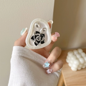 Close-up of glitter resin phone grip featuring a black rose and sparkling rhinestones