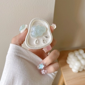 Detail of glittery blue cloud phone grip with teardrop crystals on wooden desk