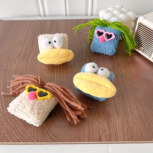 Detail of plush cartoon phone socket stand featuring funny sunglasses and big mouth design
