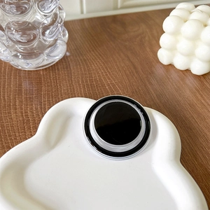 Minimalist magnetic round phone socket stand in black on a white ceramic tray
