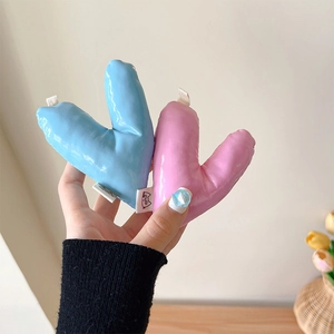 Puffy heart-shaped leather phone stands in light pink and blue with cute fabric labels
