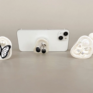 Detailed view of resin phone grips featuring butterfly and cherry patterns with pearl finish