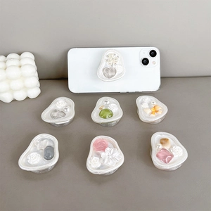 Floral and heart gem phone grip set with pearls and rhinestones on a gray surface