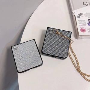 Detail of luxury glitter phone case with silver rhinestones and gold crossbody chain strap