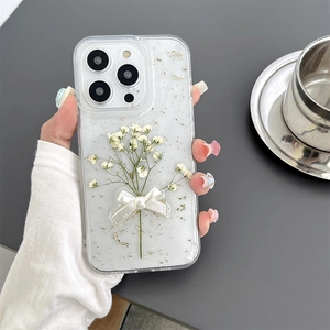 Detail of transparent iPhone case with gold foil, floral motifs and white 3D bow