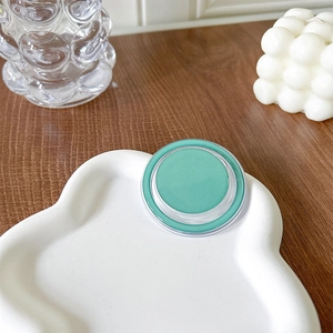 Detail of mint green solid balm in minimalist round case on cloud-shaped display tray
