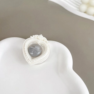 Detail of heart-shaped marble grip tok with white relief border on a cloud ceramic tray