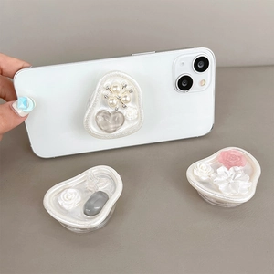 Floral resin phone socket with pearls and heart gems shown on a smartphone