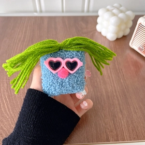 Blue plush monster phone stand with heart sunglasses and long green hair on wooden desk
