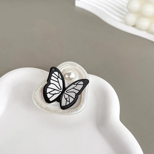 Detail of butterfly phone grip with black and white texture and pearl center accent