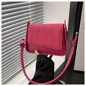 Detail of pink woven texture crossbody bag with asymmetrical flap and knotted strap