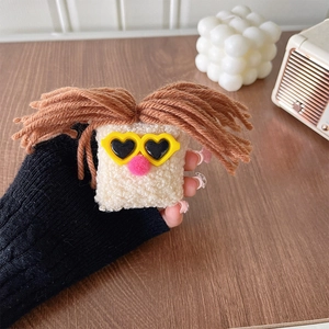 Close-up of funny plush phone grip with big mouth and sunglasses on wooden desk