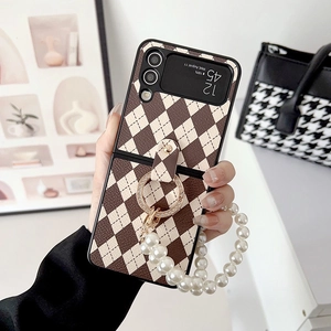 Détail d'une coque Galaxy Z Flip matelassée avec chaîne de perles et anneau strass