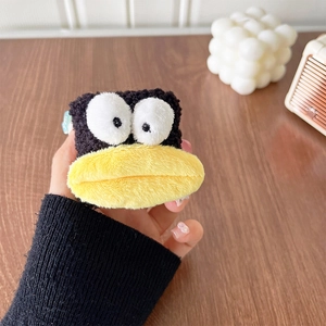 Detail of plush black duck phone socket holder with big eyes and yellow beak