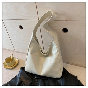 Detail of cream white tote bag with geometric stitching on a warm lifestyle background
