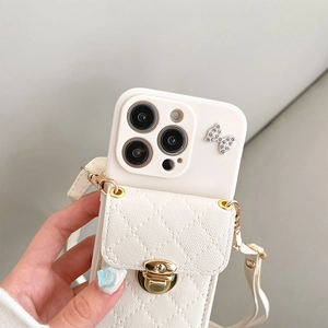 Detail of cream quilted phone case with gold lock, rhinestone bow and crossbody strap
