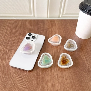 Detail of heart-shaped liquid quicksand phone sockets in five pastel colors on a phone