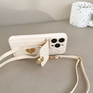 Cream leather phone case with quilted wallet, bow accent and crossbody strap for iPhone