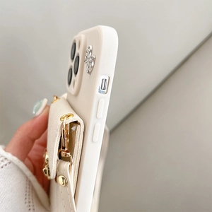 Macro detail of cream leather phone case with card holder and gold hardware