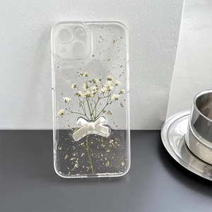 Clear iPhone case with white dried flowers, gold foil, and a 3D ribbon bow ornament