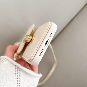 Detail of cream leather phone case with secure clasp wallet and crossbody strap attachment