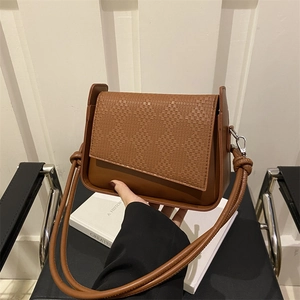 Brown leather quilted shoulder bag with woven texture flap and knotted strap detail