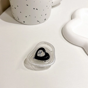Close-up of heart-shaped phone grip with black resin and sparkling crystal detail