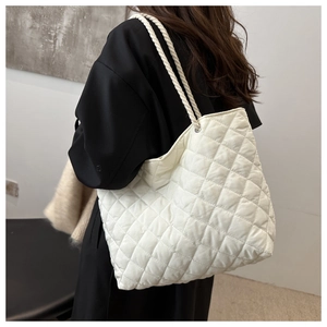 Détail du sac fourre-tout matelassé blanc avec anses en corde tressée et œillets en métal