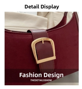Detailed close-up of burgundy leather underarm bag with elegant gold metal buckle