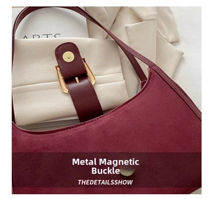 Detail of burgundy suede shoulder bag with vintage gold magnetic buckle closure